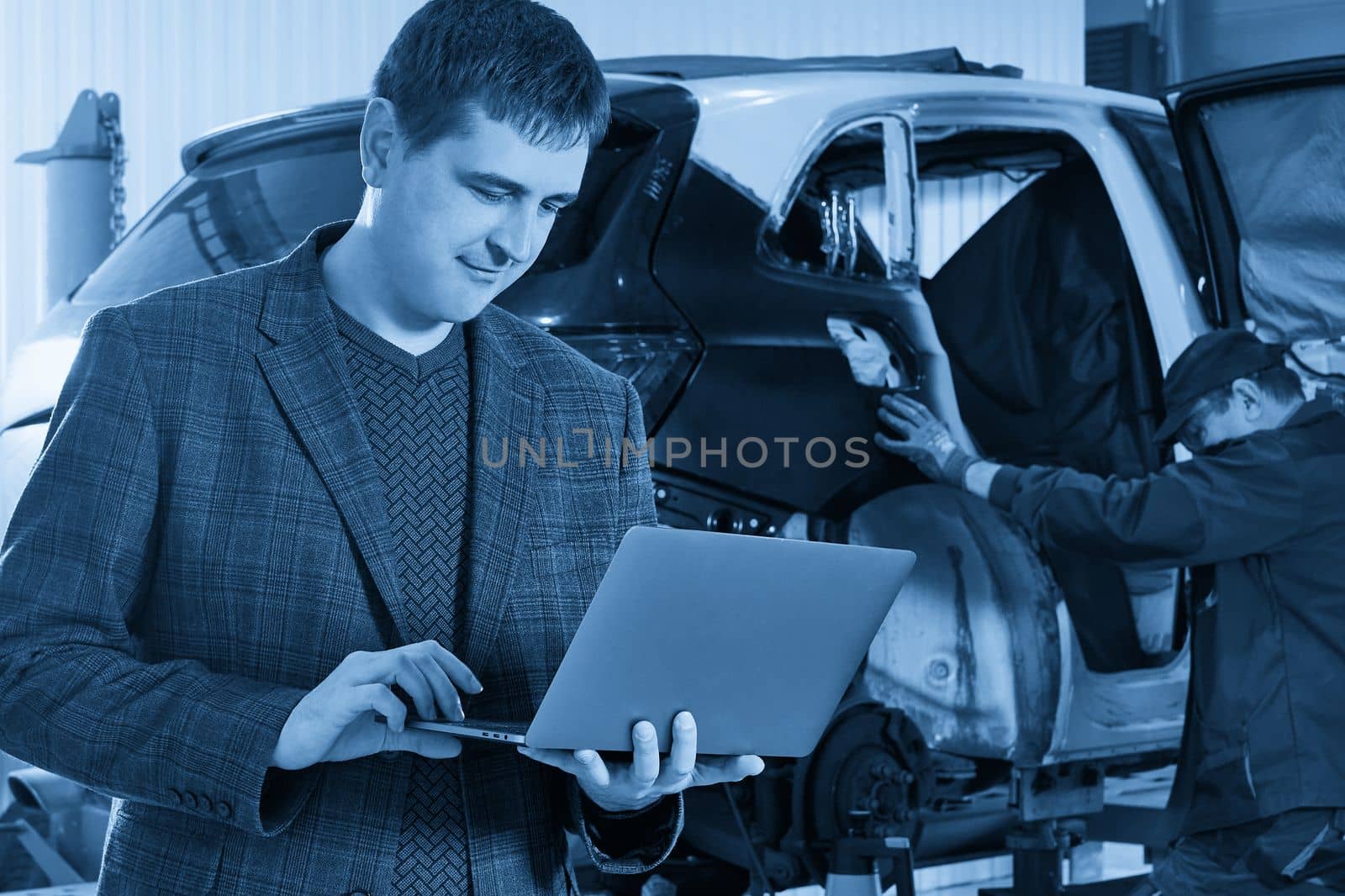 Auto mechanic and technician working in repair shop by Mariakray