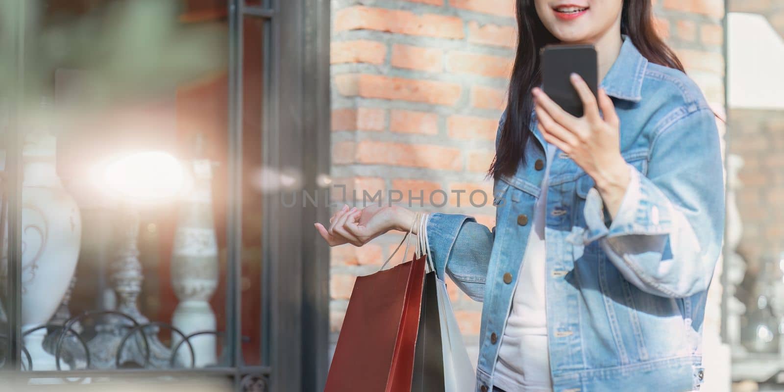 Asian fashionable woman walking at shopping mall with shopping bags while flash sale promotion by itchaznong