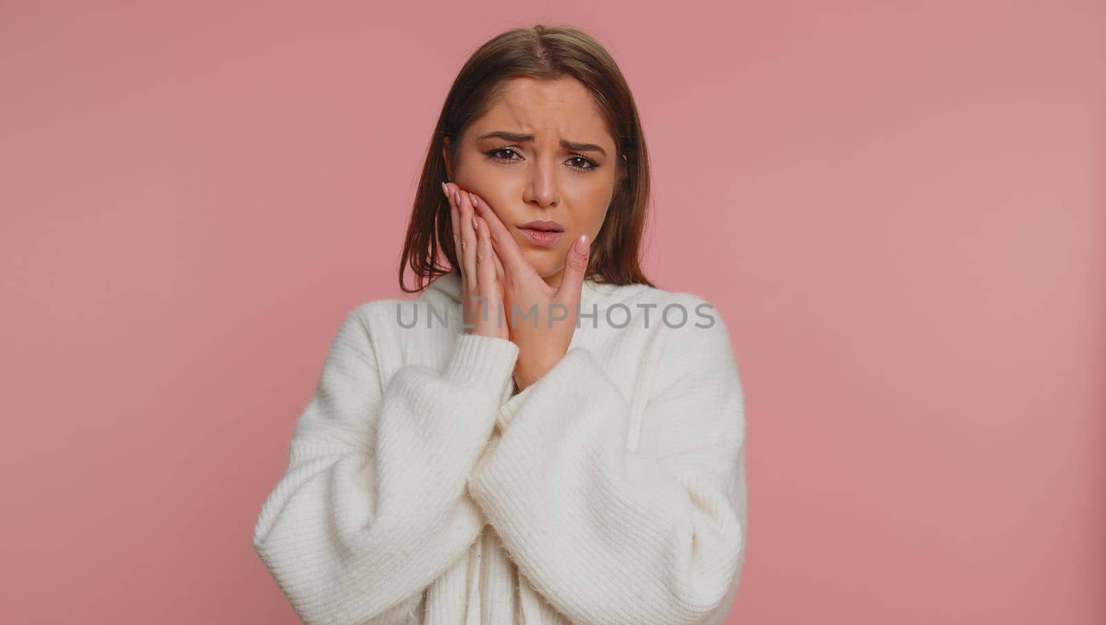 Woman touching cheek suffering from toothache cavities or gingivitis waiting for dentist appointment by efuror