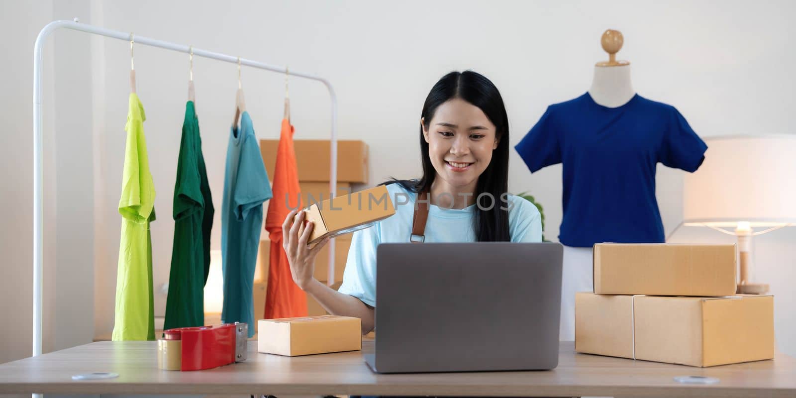 Young woman small business owner working at home office. Online marketing packaging delivery, startup SME entrepreneur or freelance woman concept.