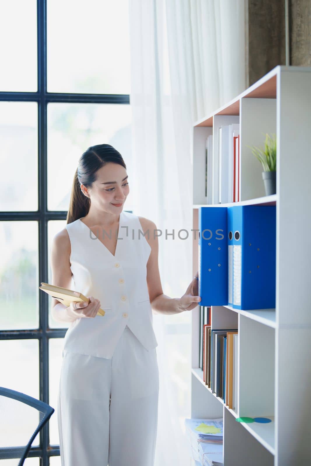 portrait of Asian female employees notebooks and pick up important documents to start their morning work