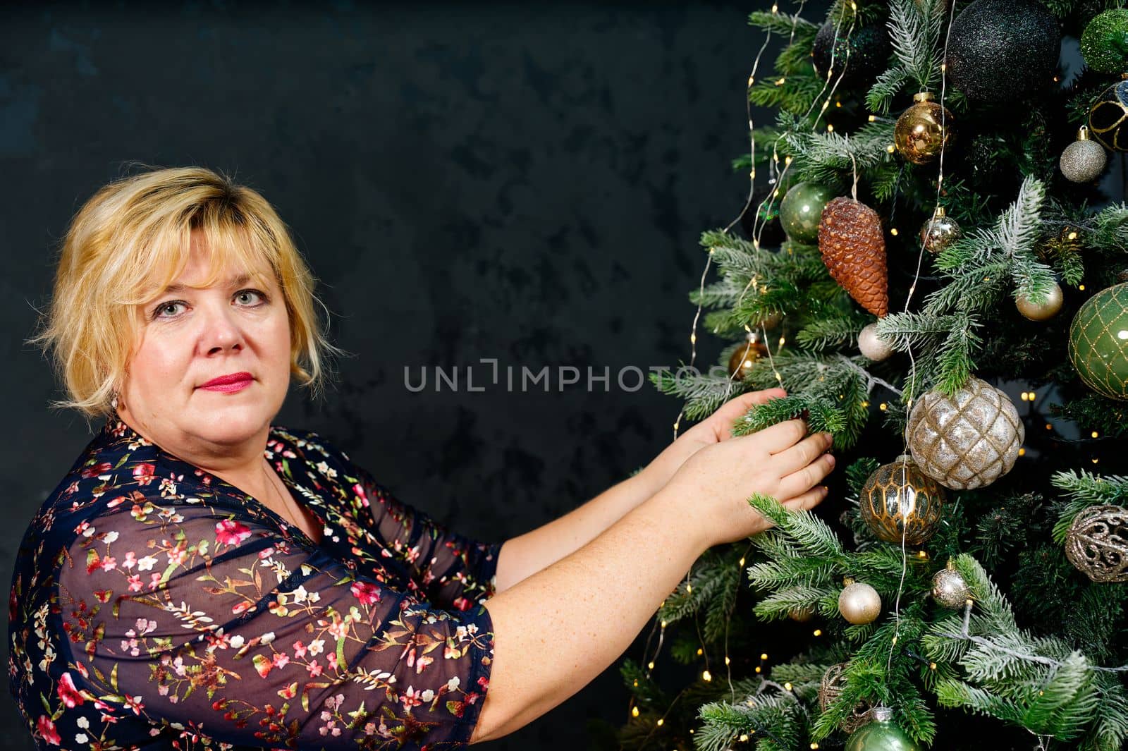 Overweight Woman decorating beautiful Christmas tree at home, closeup. christmas holidays and people concept. by PhotoTime