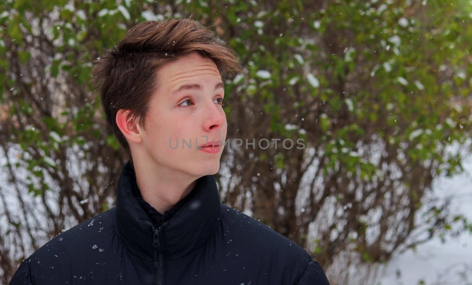 Portrait of a teenage boy close-up on a background of snow. by gelog67