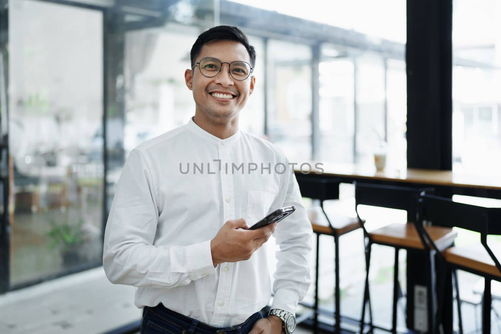 business owner or Asian male marketers are using business phones in office work by Manastrong