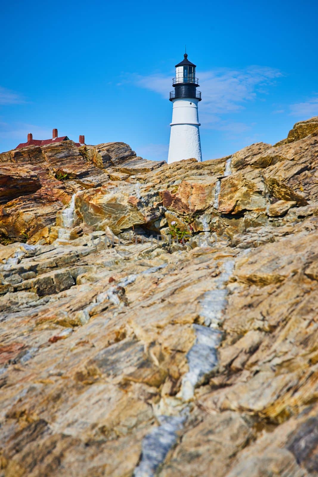Small mineral quartz vein in rocks leading to white lighthouse by njproductions