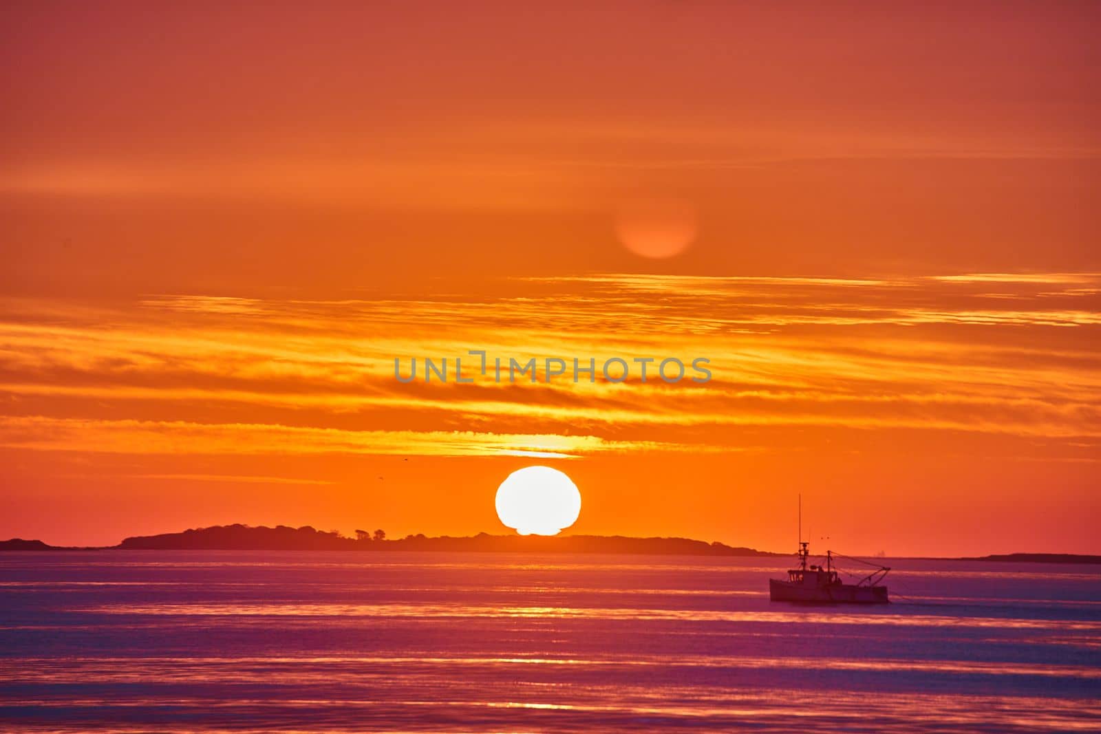 Image of Stunning sunrise detail of sun and ocean coast with fishing ship and golden light