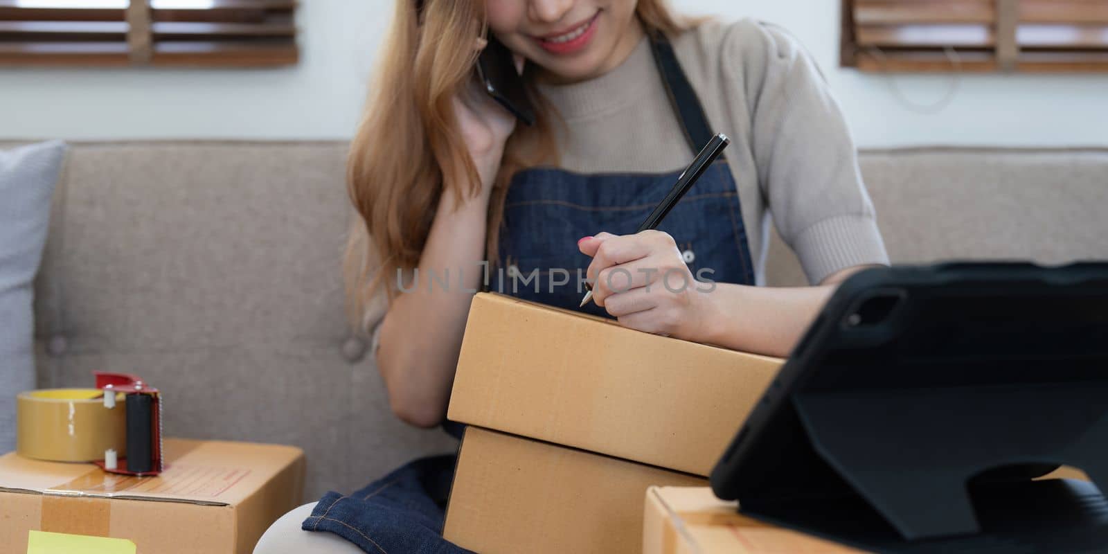 Startup small business entrepreneur of freelance Asian woman using a laptop with box Cheerful success online marketing packaging box and delivery SME idea concept.