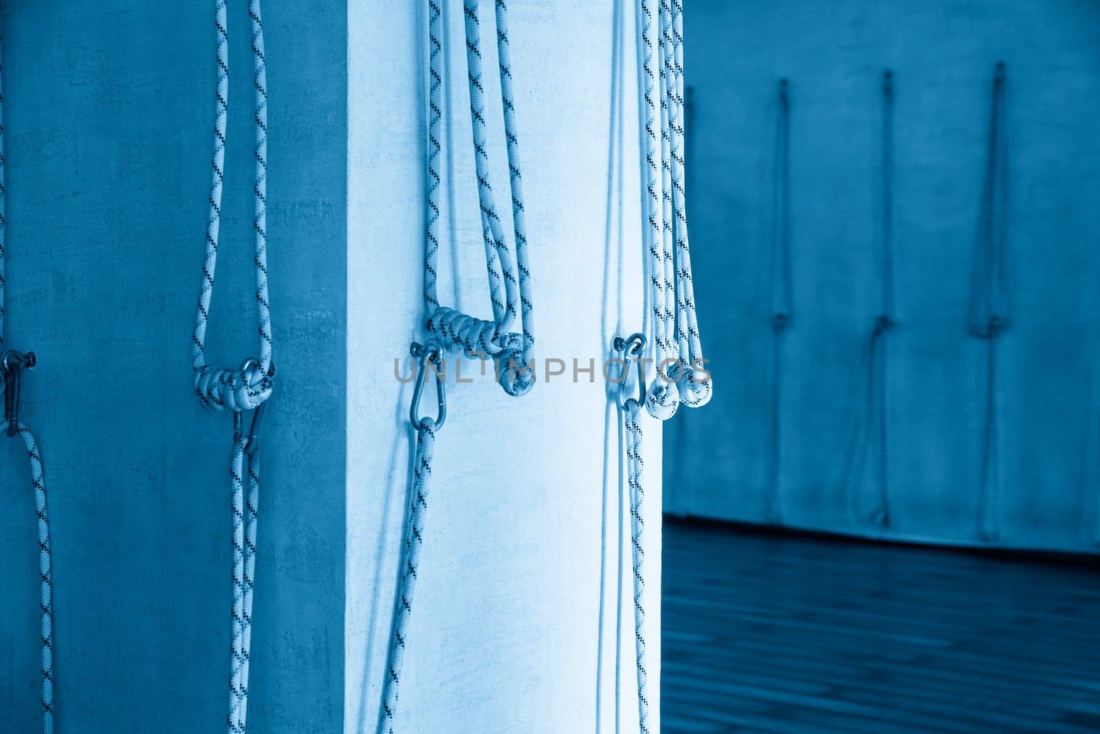 Yoga ropes hanging on empty studio wall. Iyengar yoga by Mariakray