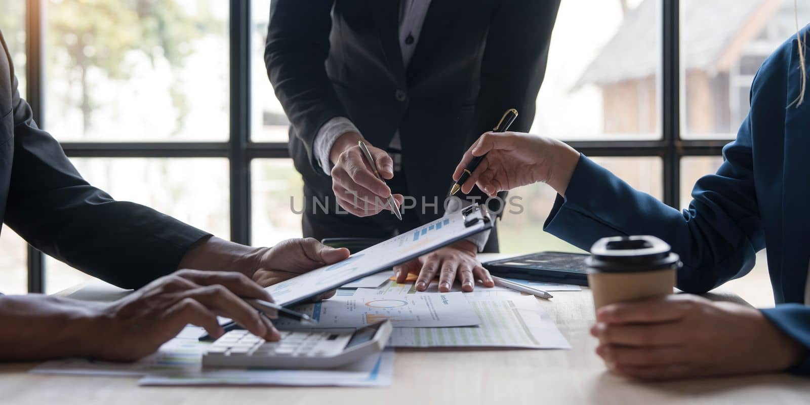 Business People Meeting using laptop computer,calculator,notebook,stock market chart paper for analysis Plans to improve quality next month. Conference Discussion Corporate Concept...