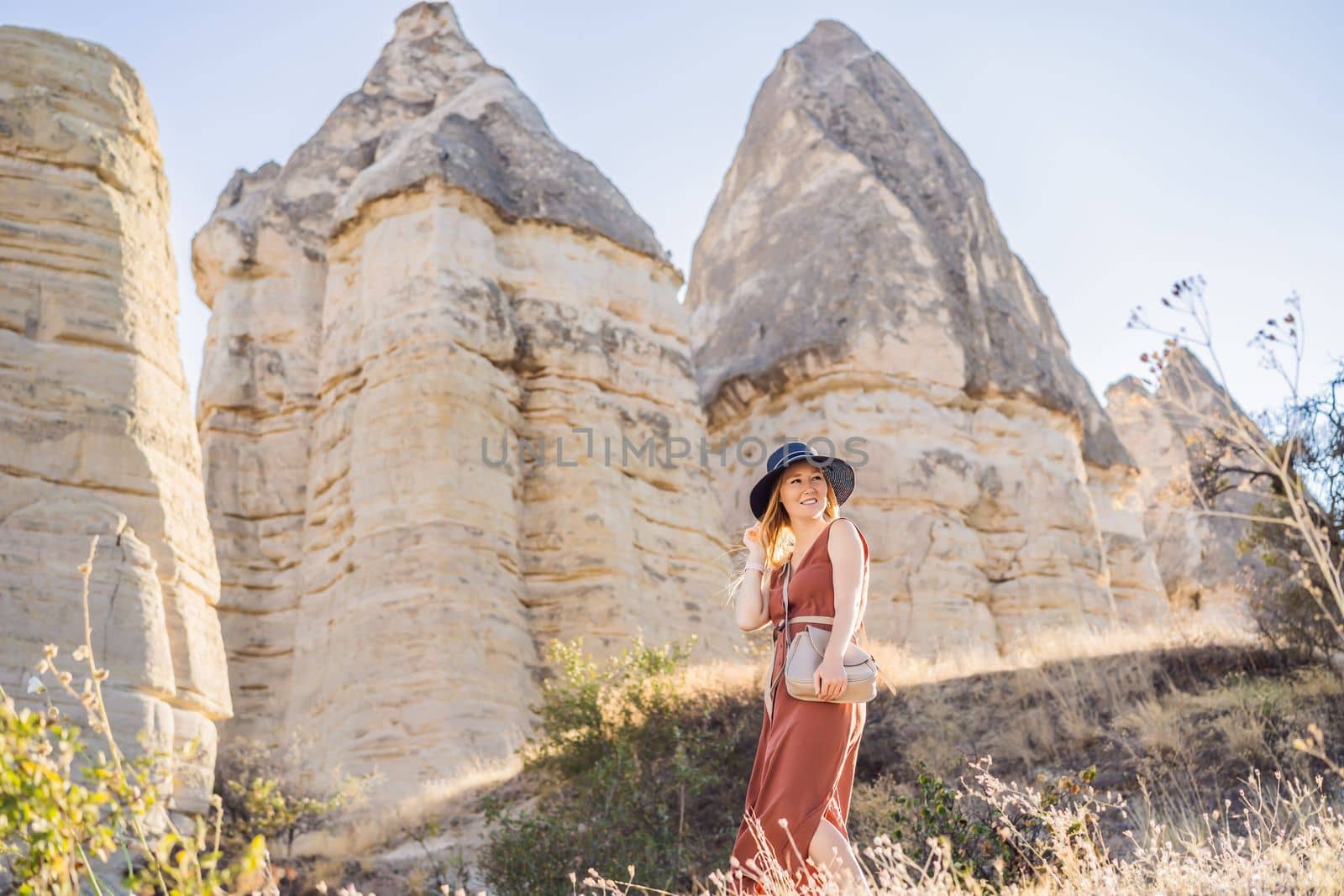 Woman tourist on background of Unique geological formations in Love Valley in Cappadocia, popular travel destination in Turkey.