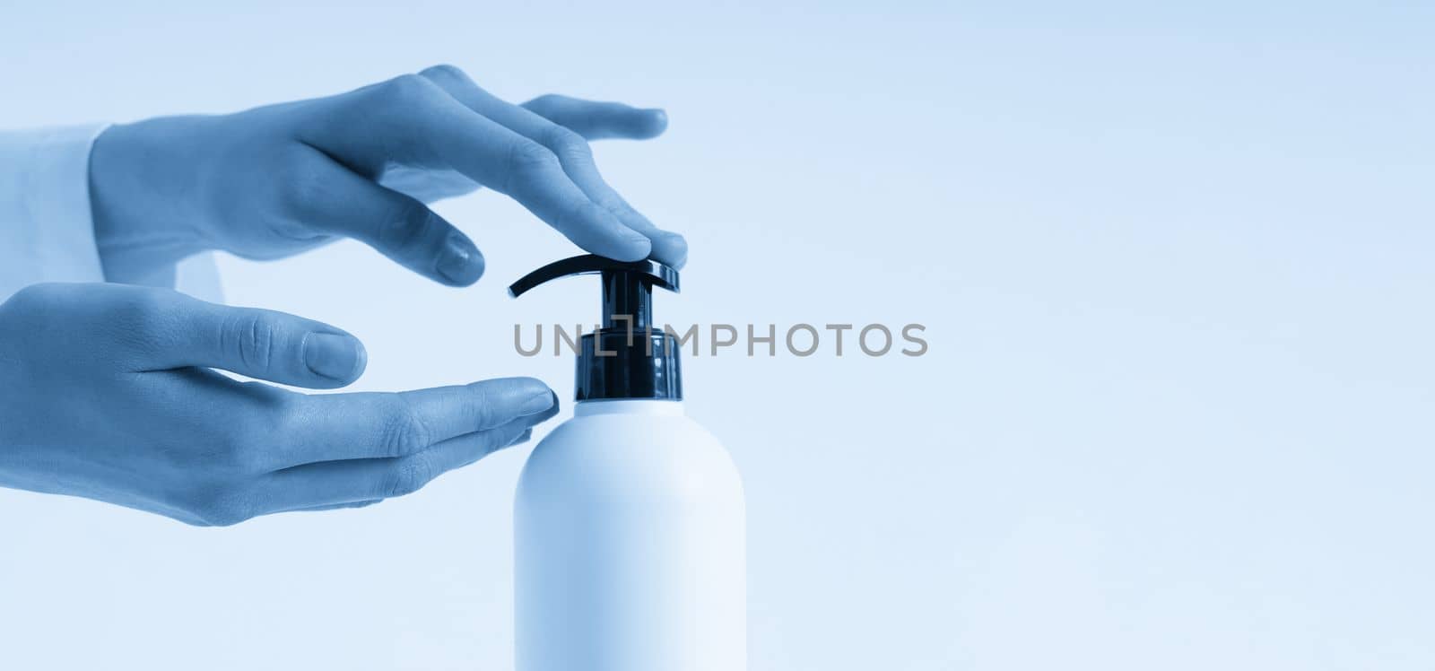Woman hands pushing pump plastic soap bottle with copy space, using wash hand sanitizer gel pump dispenser. killing germs, bacteria and virus by Mariakray