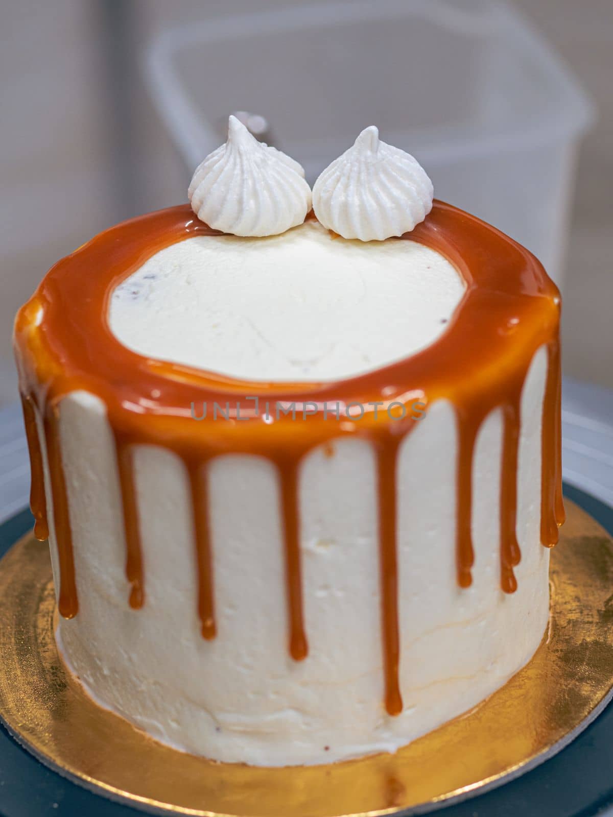 professional baker decorating a chocolate and cream cake with salty caramel
