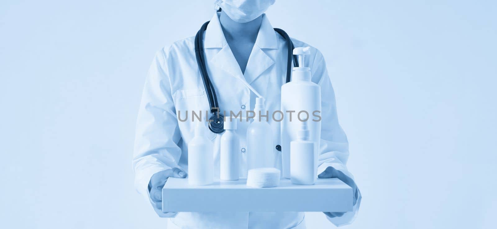 Doctor holding many bottles of hand sanitizers and liquid soap on black background by Mariakray