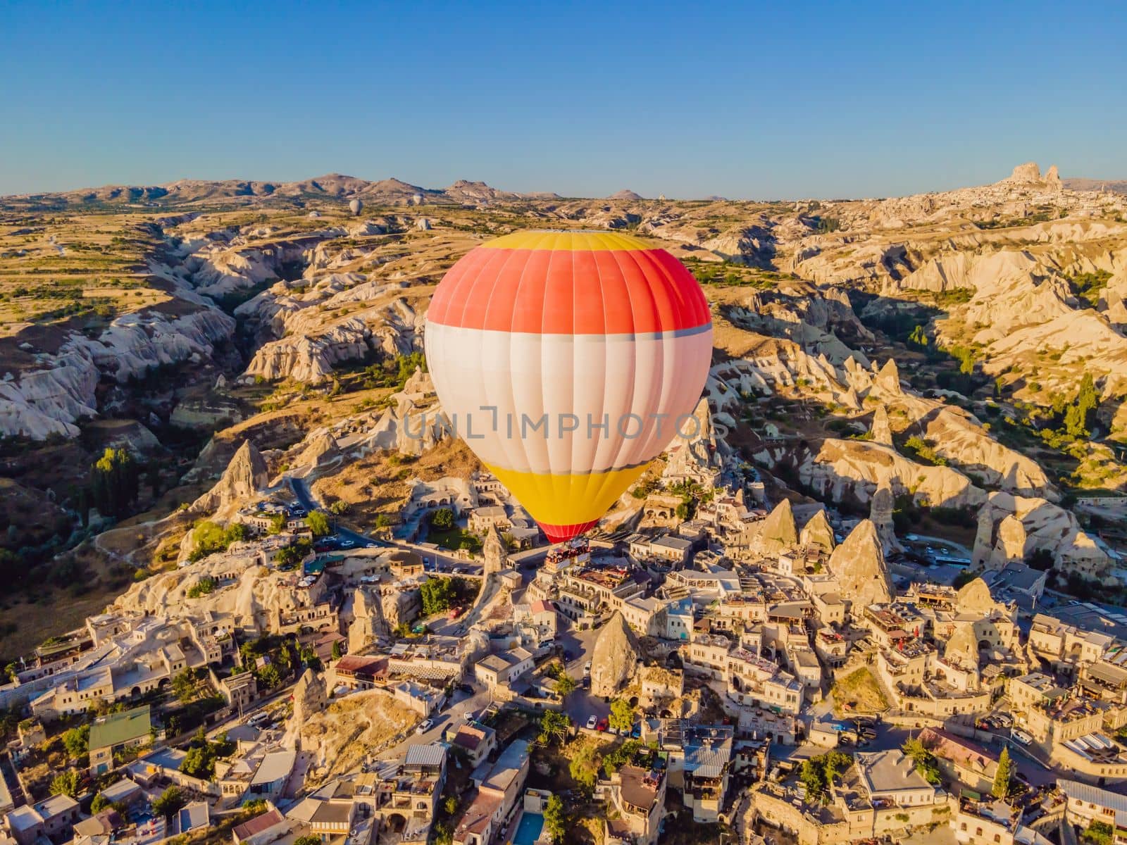 Colorful hot air balloons flying over at fairy chimneys valley in Nevsehir, Goreme, Cappadocia Turkey. Spectacular panoramic drone view of the underground city and ballooning tourism. High quality by galitskaya