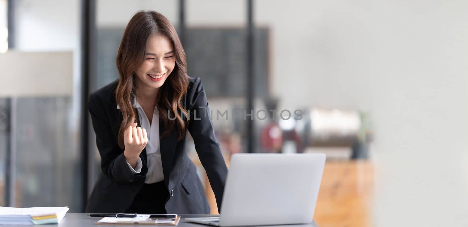 Beautiful asian woman using laptop computer, exciting and celebrating with good news of business successful. Small business startup concept. by wichayada