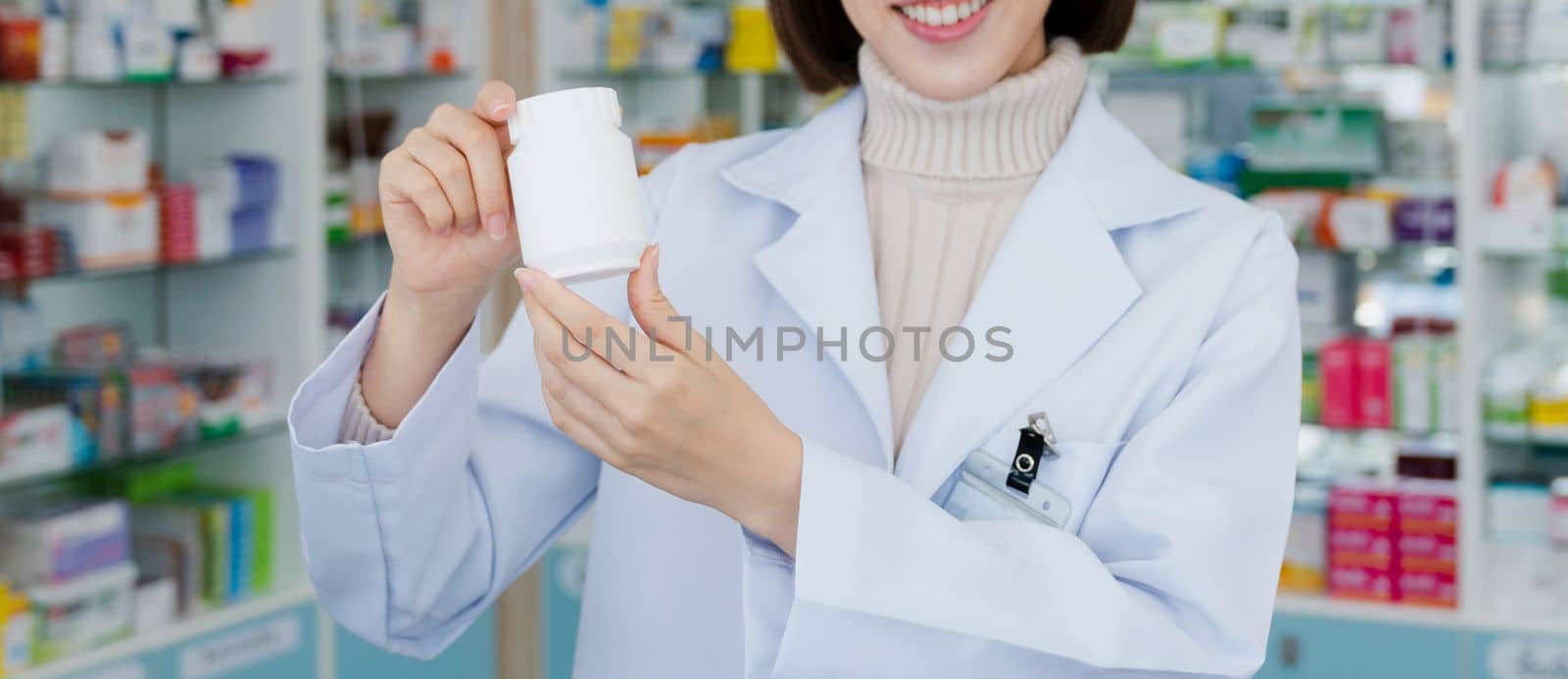 Closeup young asian pharmacist pill bottle mockup at qualified pharmacy by biancoblue