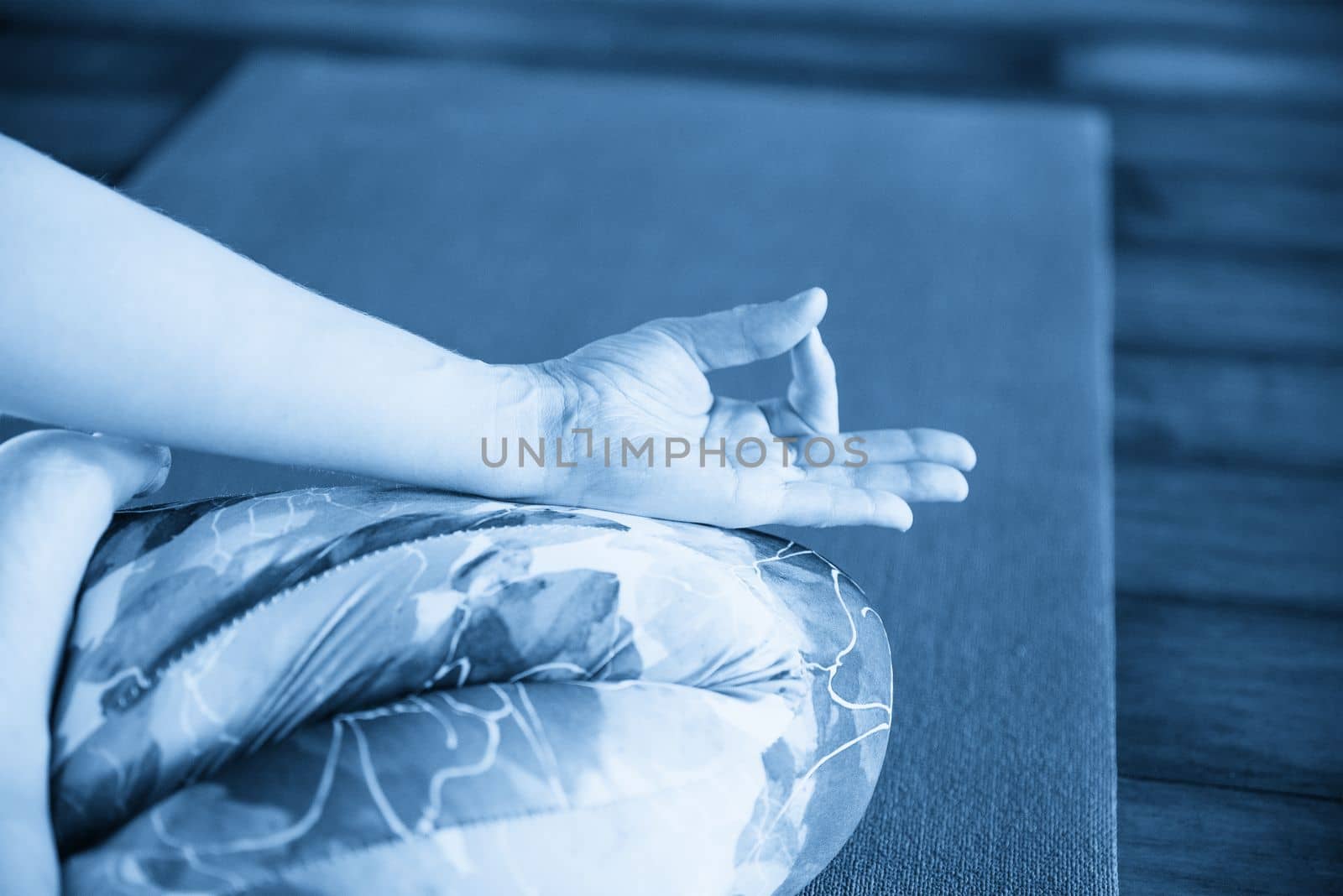 Young woman meditating sitting in lotus position by Mariakray