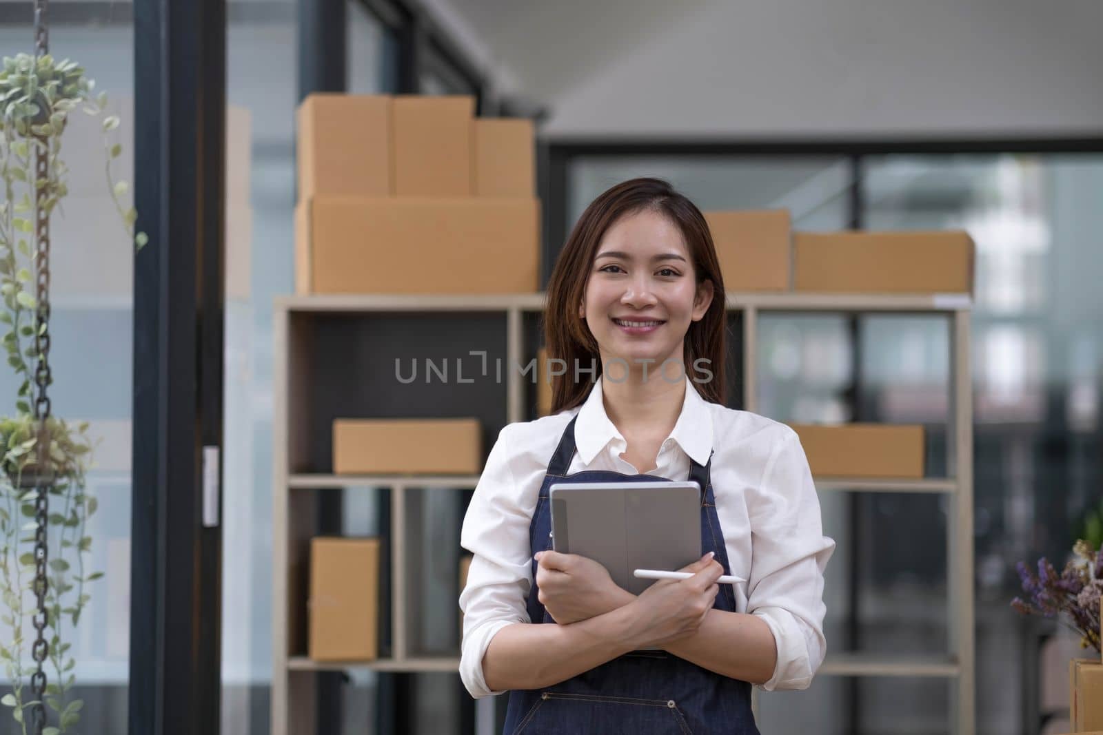 Portrait of Asian young woman SME working with a box at home the workplace.start-up small business owner, small business entrepreneur SME or freelance business online and delivery concept...