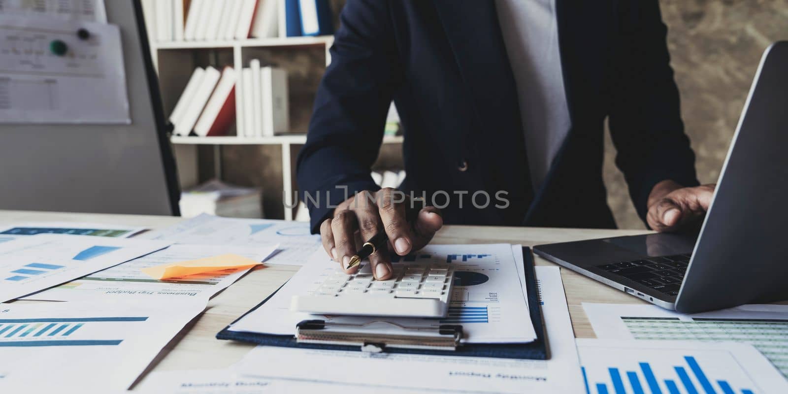 Close up man working about financial with calculator at his office to calculate expenses, Accounting concept..