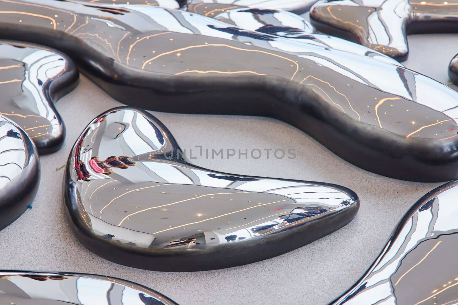 Ground detail of art exhibit melting reflecting shiny metal mirror pieces by njproductions