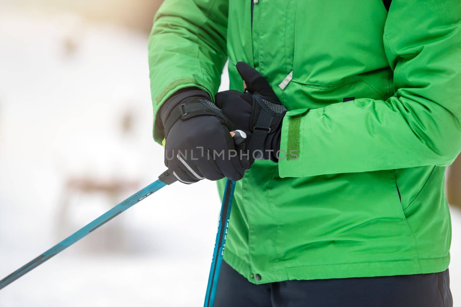 Nordic walking. Healthy lifestyle, outdoor sports in winter. A man's hand squeezes the handle of a cane for Nordic walking. Attach a stick to your hand.