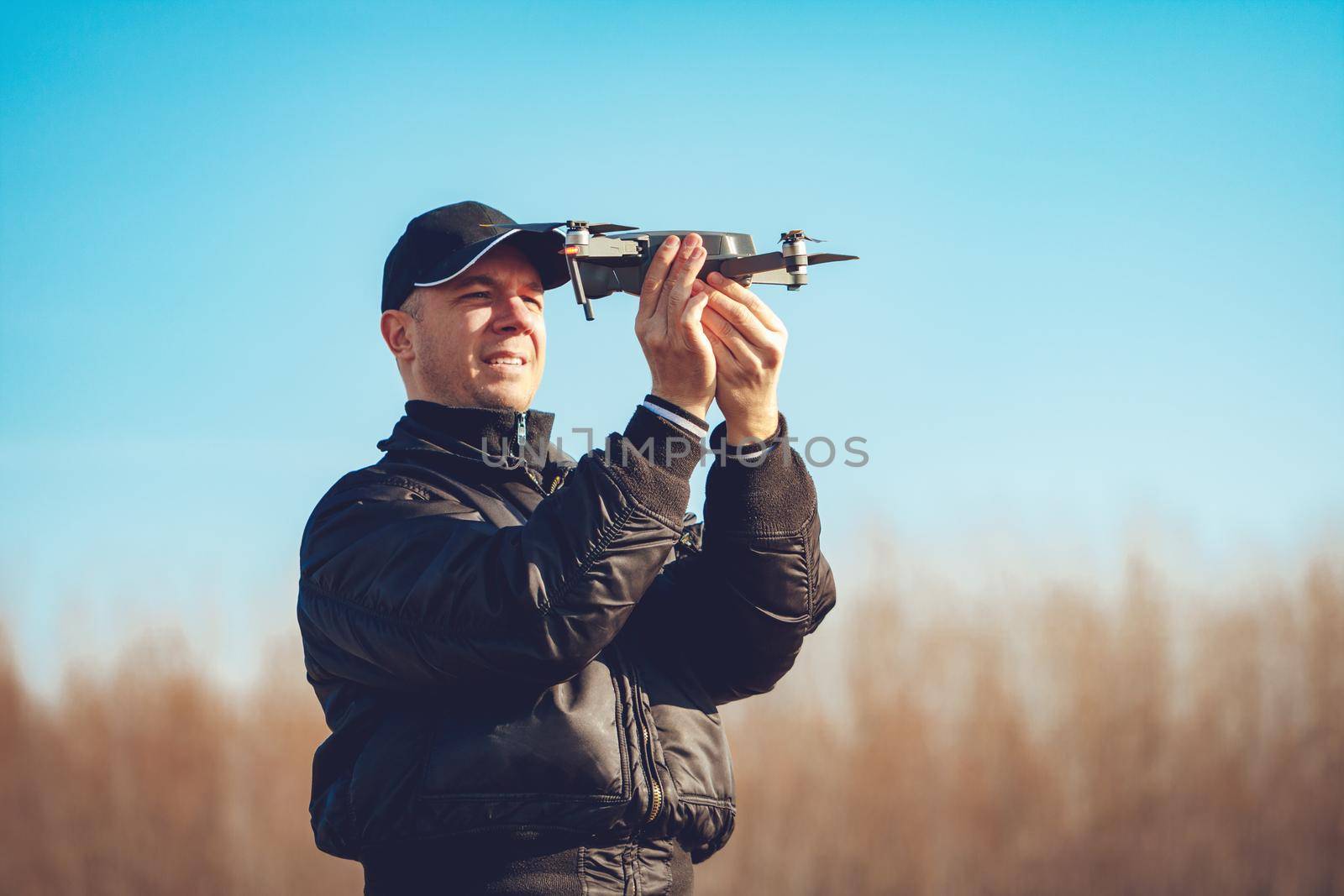 Handsome young man holding the drone, calibrating and preparing for take off.