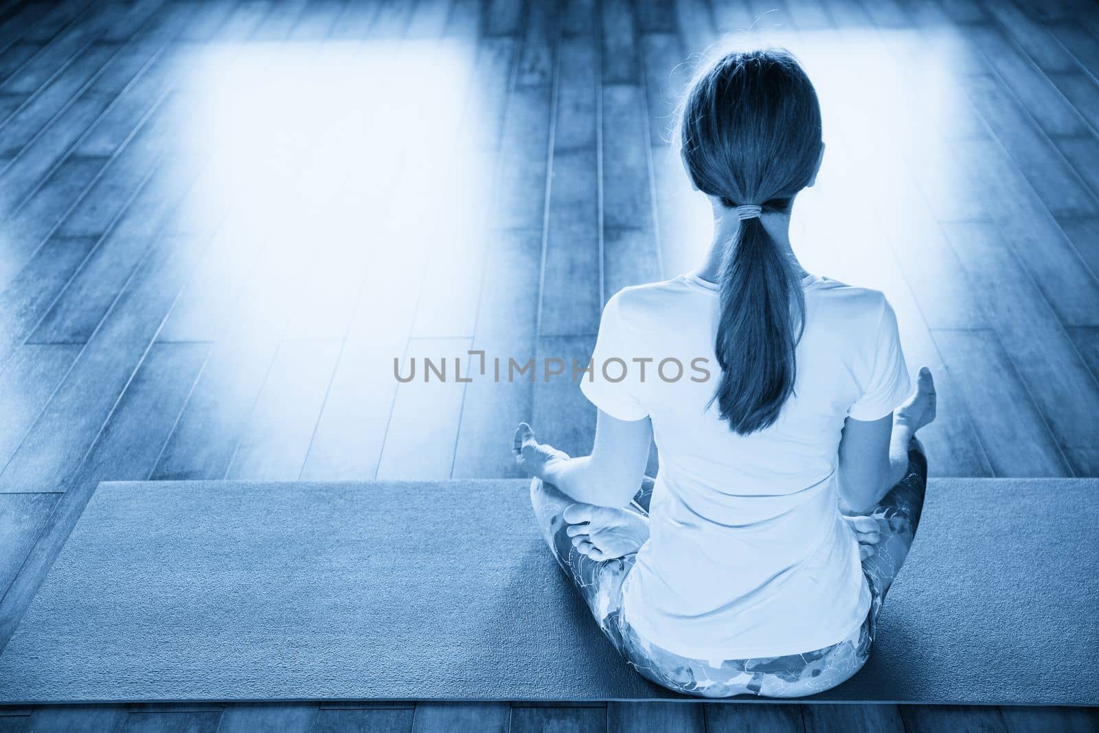 Young woman meditating sitting in lotus position