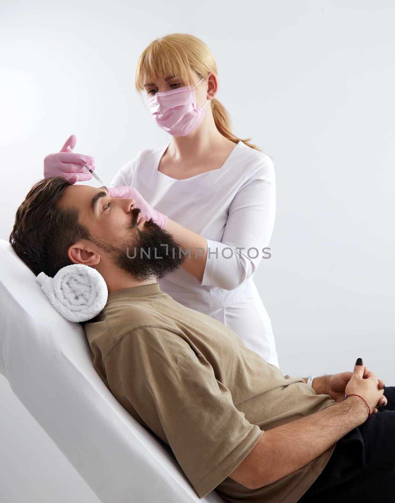Closeup of bearded man getting beauty injection at aesthetic clinic. Doctor injecting anti-aging filler in handsome male face. Male cosmetology, aesthetic medicine concept