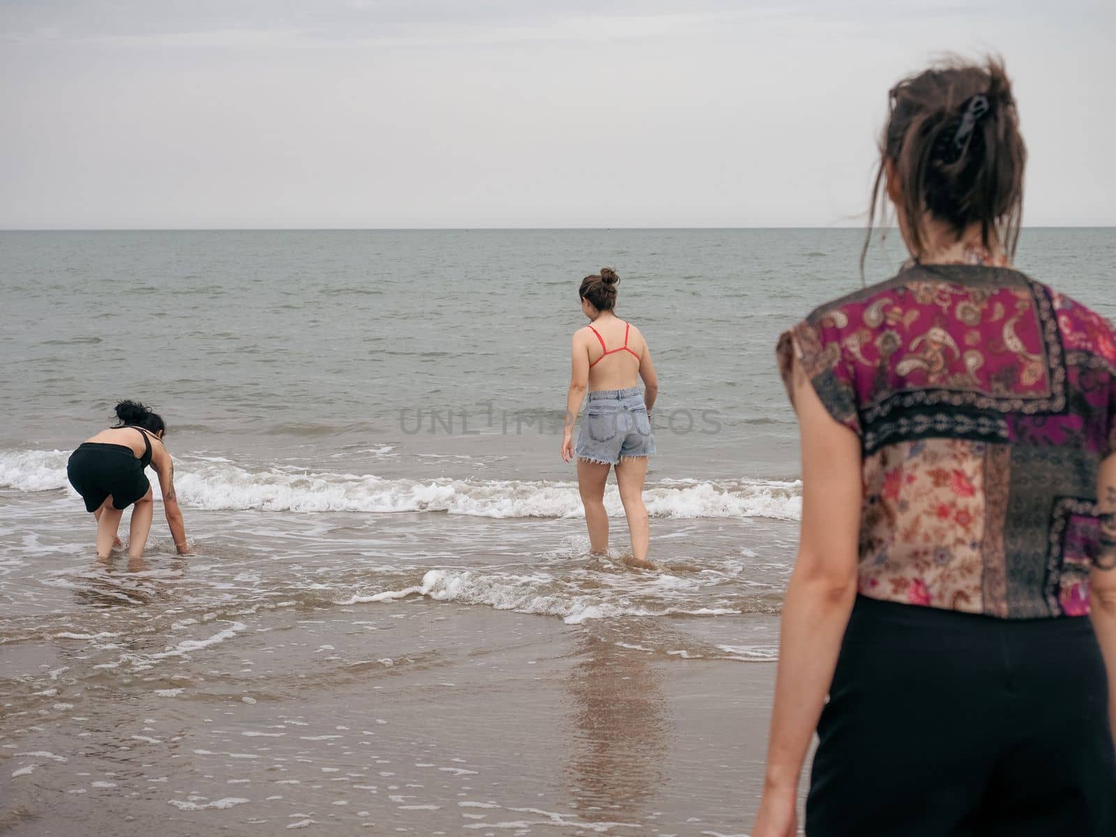 Three girls splashing each other in the beach