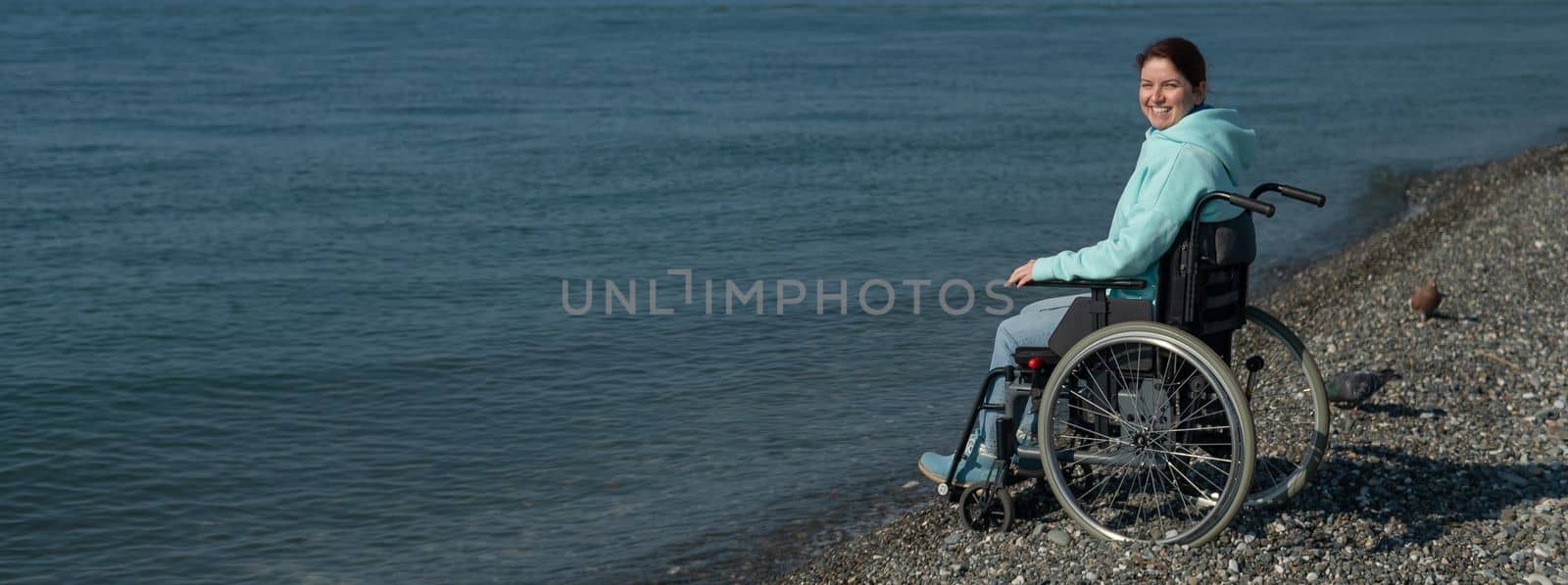 Pacified caucasian woman in a wheelchair on the seashore