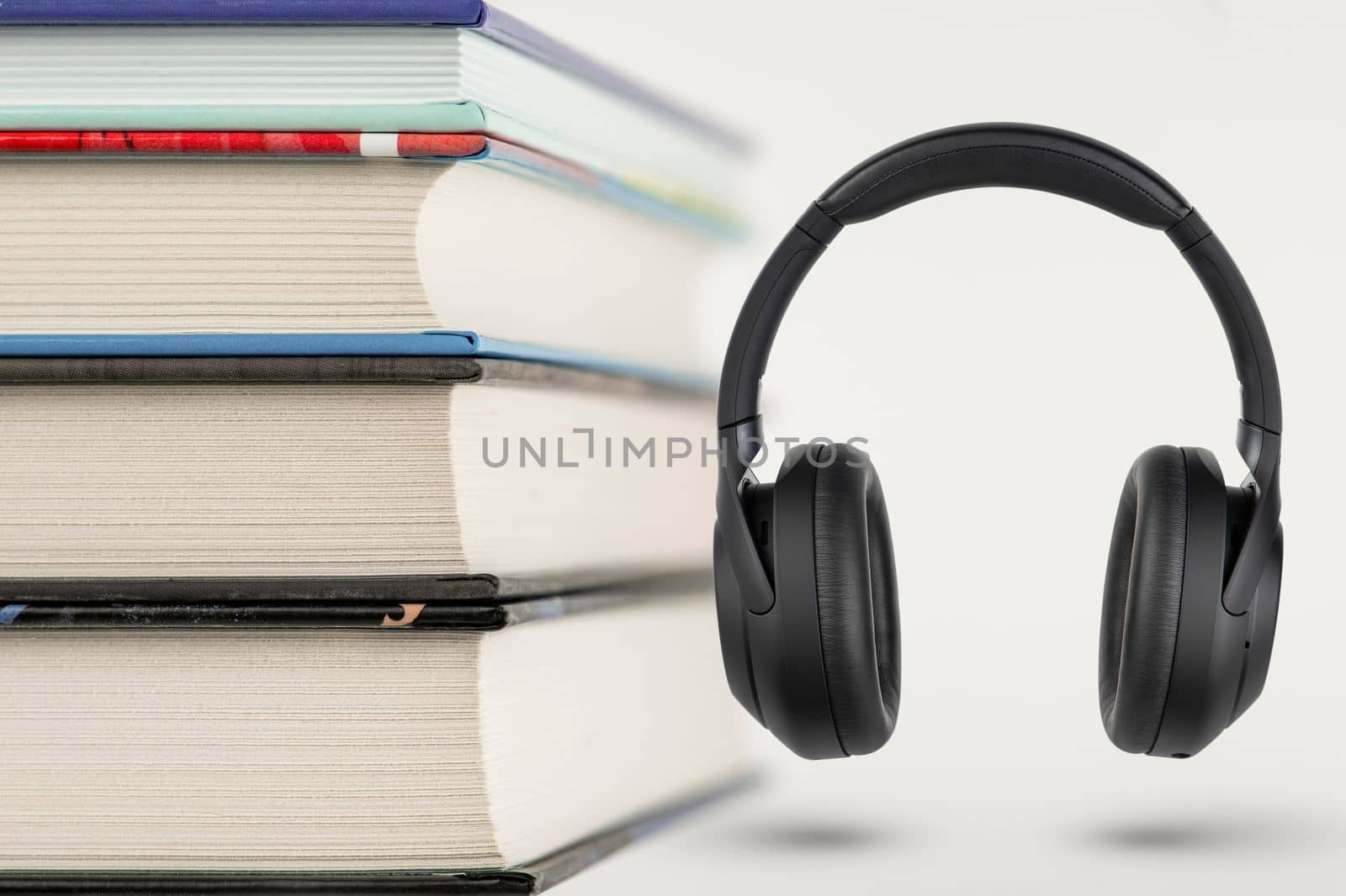 Audiobooks. Audiobook concept, stack of books and headphones with space for copy space. Choice between books and audio