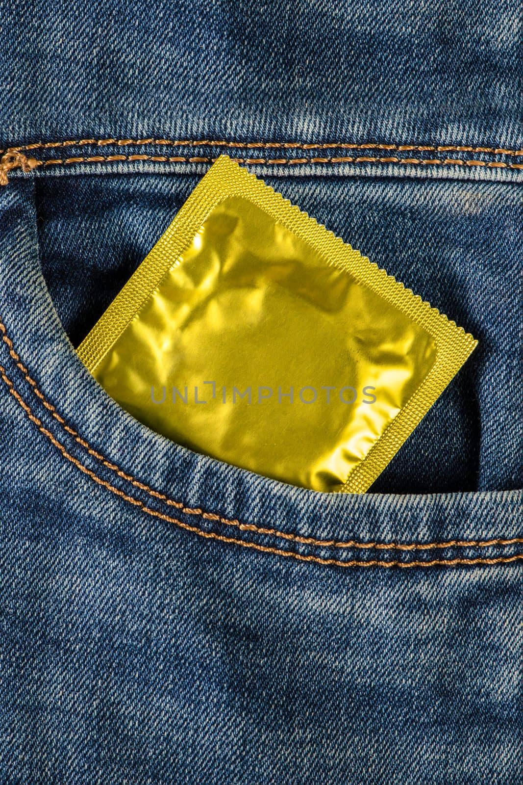 Safe sex, protection from unwanted pregnancy. Protection against sexual diseases, condoms in the pocket of blue jeans