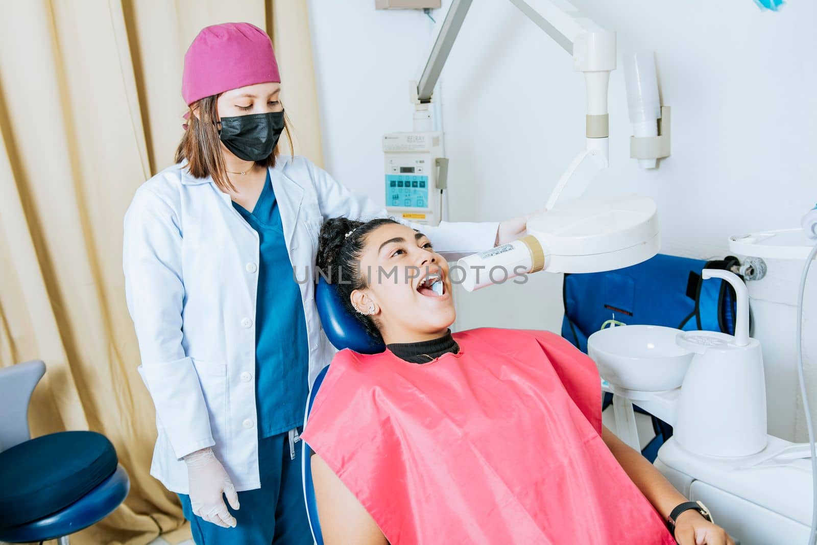 Dentist performing intraoral dental x-ray on a patient, Dentist performing intraoral x-ray assessment on a patient, a dentist performing dental x-rays in the office. Intraoral radiography concept by isaiphoto