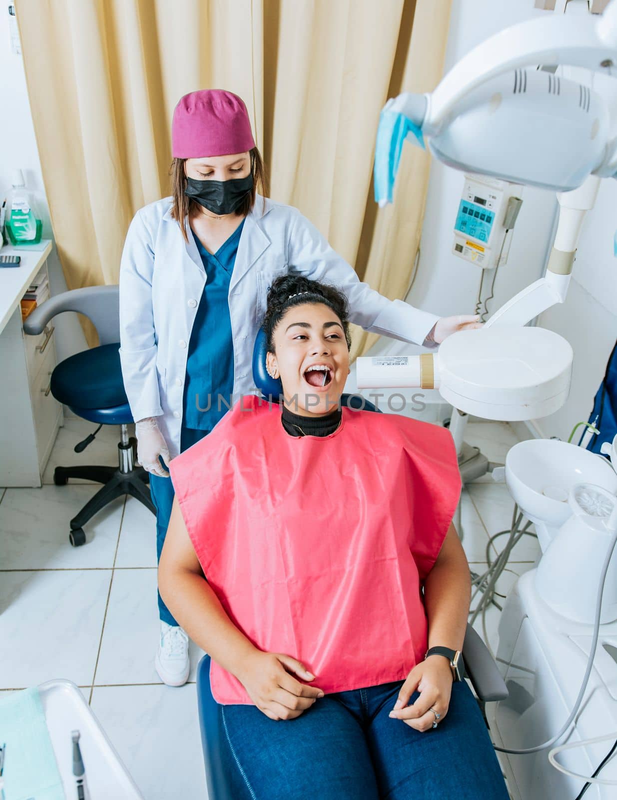 Dentist performing intraoral radiography assessment on a patient, a dentist performing dental x-rays in the office. Intraoral radiography concept, Dentist performing intraoral dental x-ray on a patient by isaiphoto