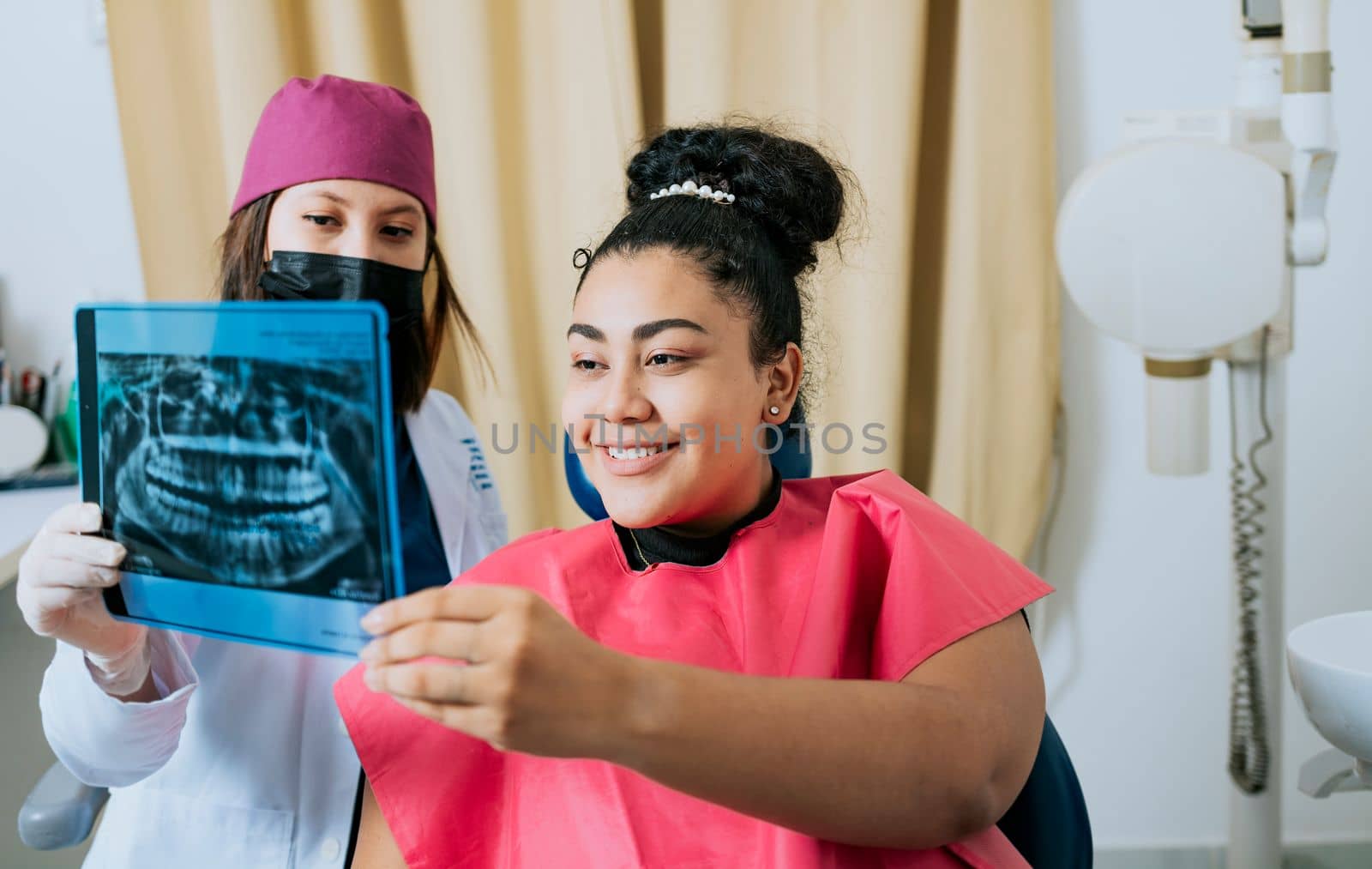 Patient looking at x-ray with dentist, Concept of dentist showing x-ray examination to female patient, Dentist showing patient x-ray. Dentist with patient reviewing the x-ray