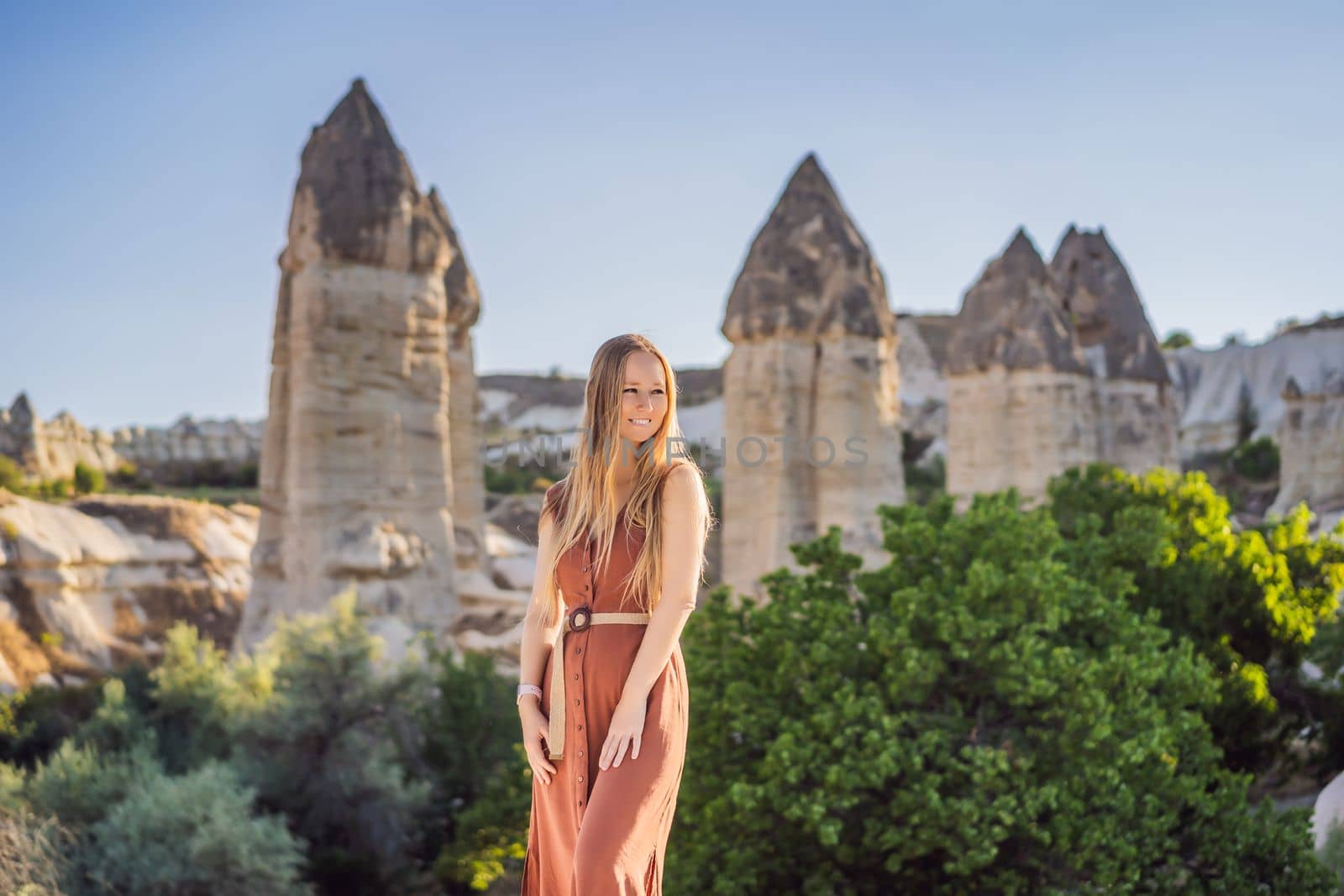 Woman tourist on background of Unique geological formations in Love Valley in Cappadocia, popular travel destination in Turkey.