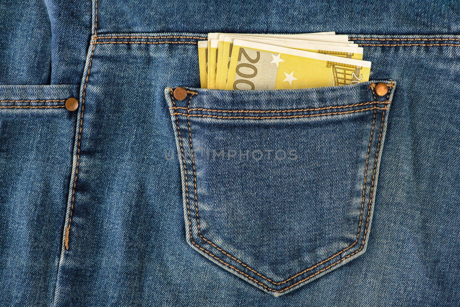 A stack of 200 euro bills in a jeans pocket. Money in the back pocket of my jeans. The concept of investment, cash, wealth and profit. copyspace