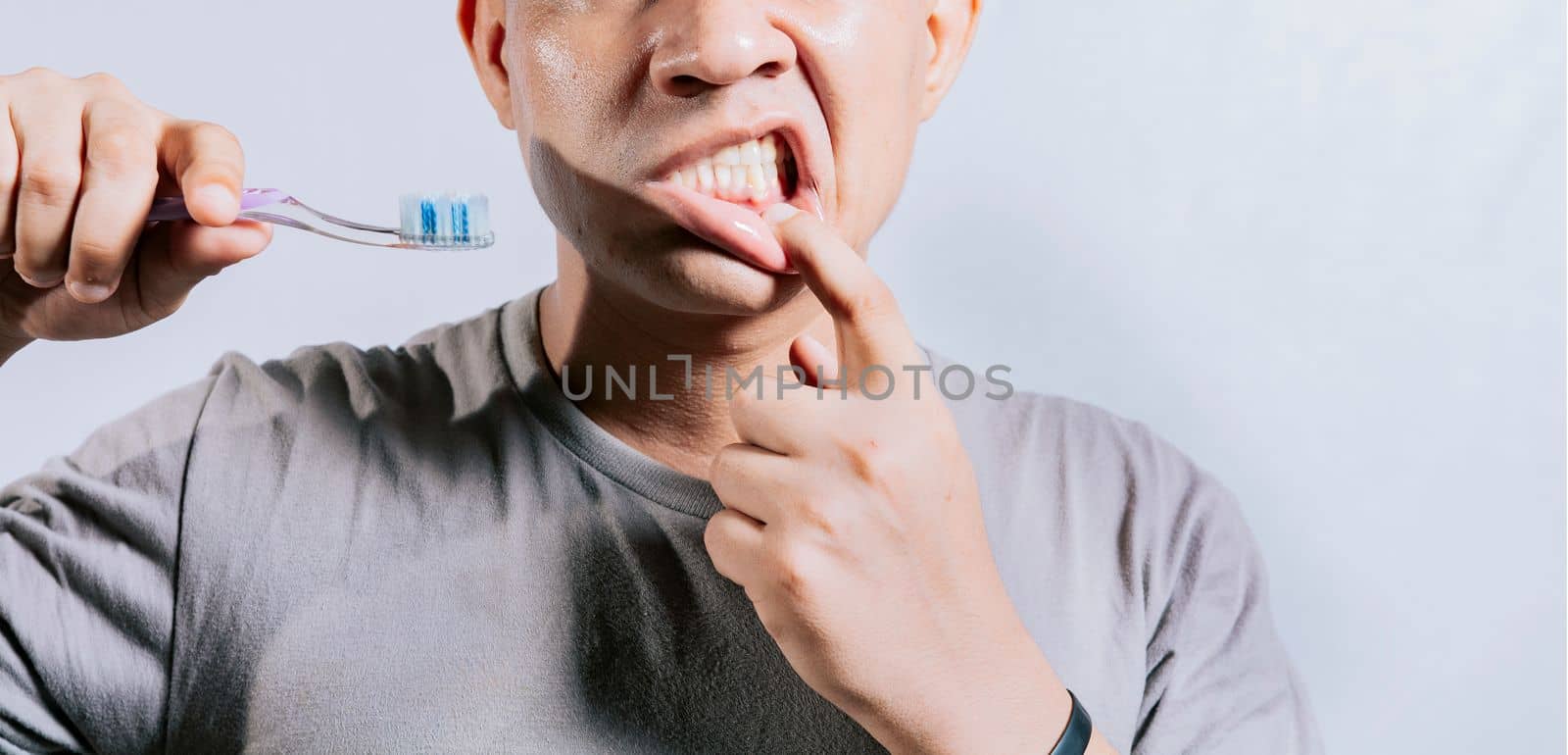 Person with gingivitis holding toothbrush. People holding toothbrush with gum pain. Man holding toothbrush with gum pain, People holding toothbrush with gum problem isolated by isaiphoto