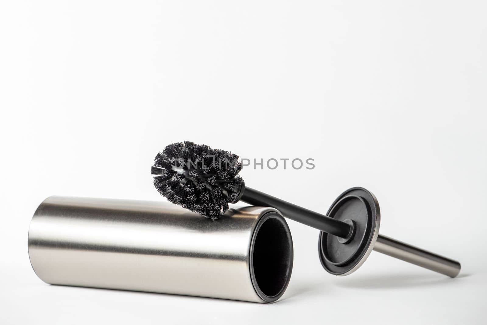 Black toilet brush isolated on white. Close-up of a toilet cleaning brush with metal elements to insert into a project or design. Metal brush for the toilet on a white background