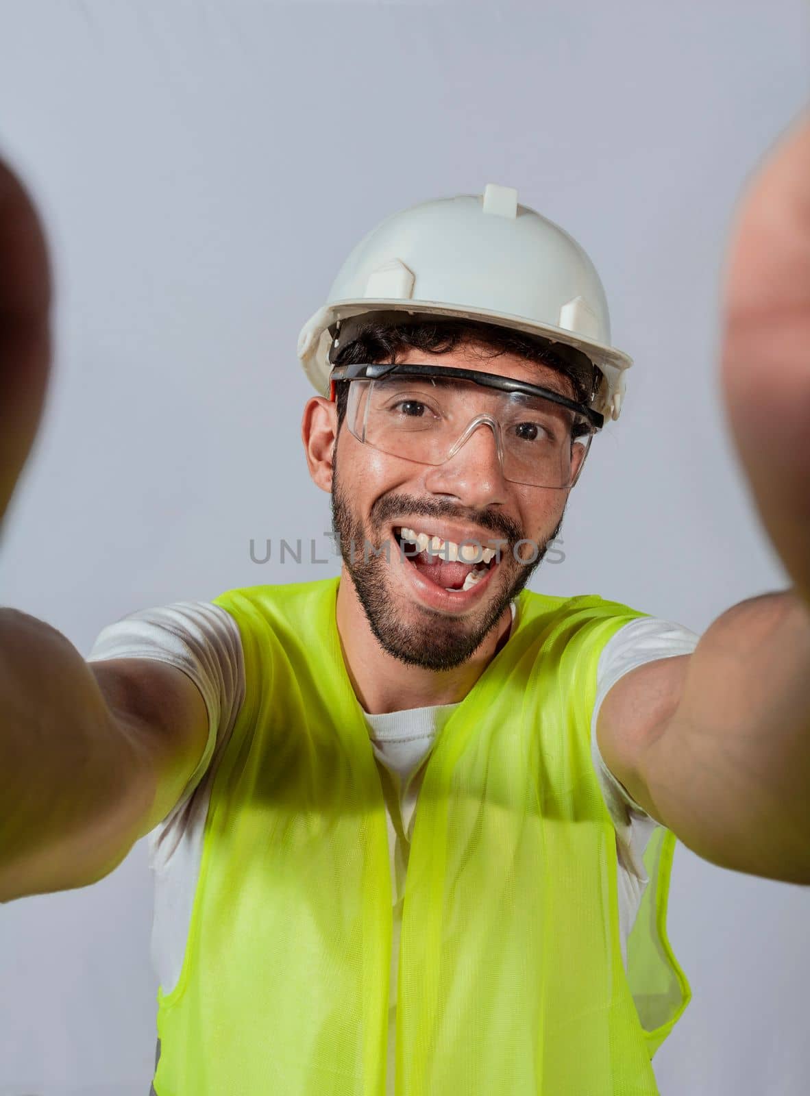 Funny builder engineer taking a selfie isolated, Engineer taking a selfie isolated. View of male engineer taking a selfie isolated, Smiling male engineer taking a selfie looking at camera