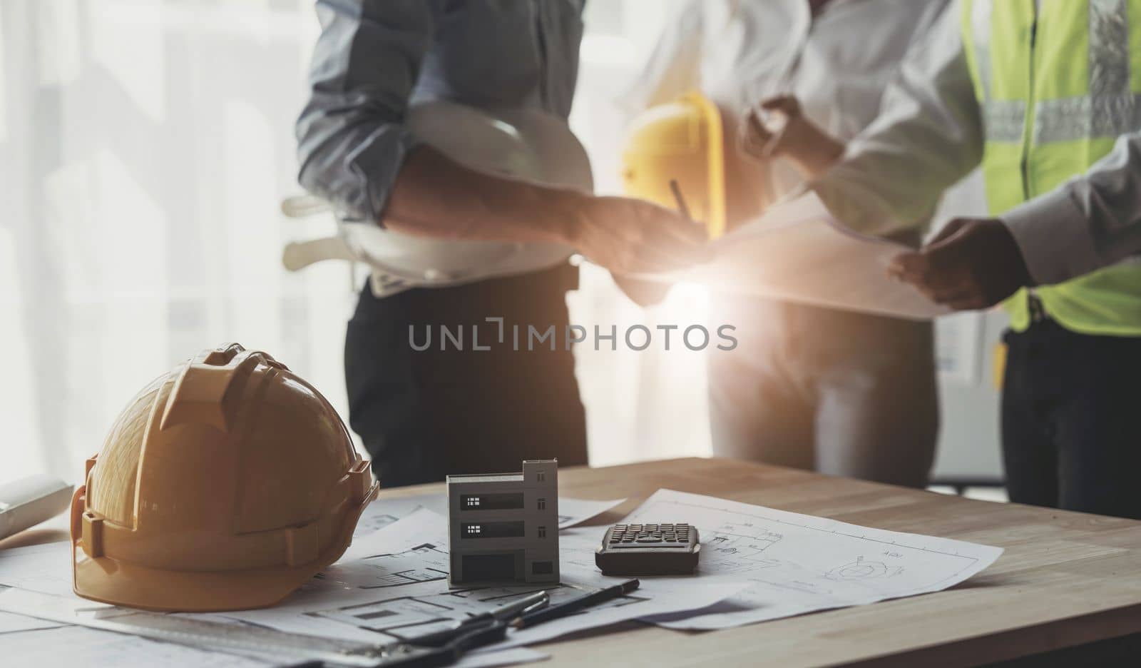 Civil engineer teams meeting working together wear worker helmets hardhat on construction site in modern city. Foreman industry project manager engineer teamwork. Asian industry professional team...