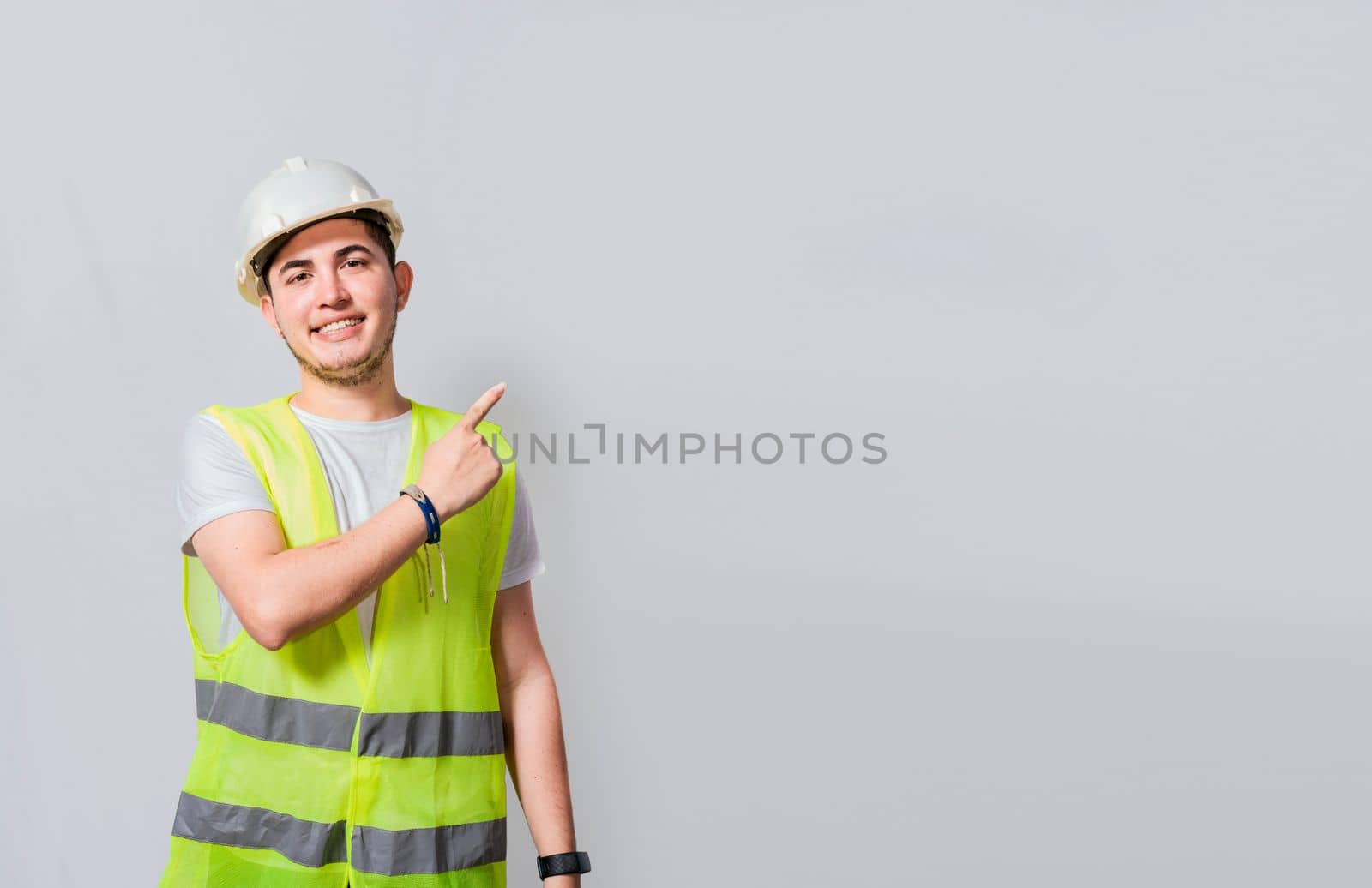 Engineer man pointing to side. Builder engineer pointing finger to the right isolated, Portrait of engineer man pointing aside, Construction engineer with vest pointing at an advertisement