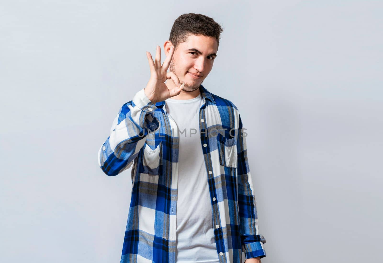 Handsome guy gesturing everything is ok, Person making ok gesture isolated, Smiling man showing ok gesture looking at camera, Concept of expression of everything is fine.