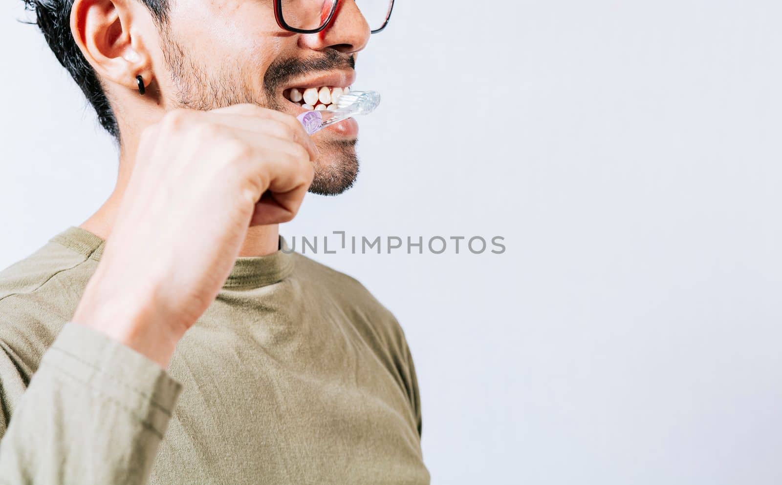 Face of person brushing teeth isolated with copy space. Man brushing his teeth isolated, Face of handsome man brushing his teeth with copy space. Tooth care and brushing concept