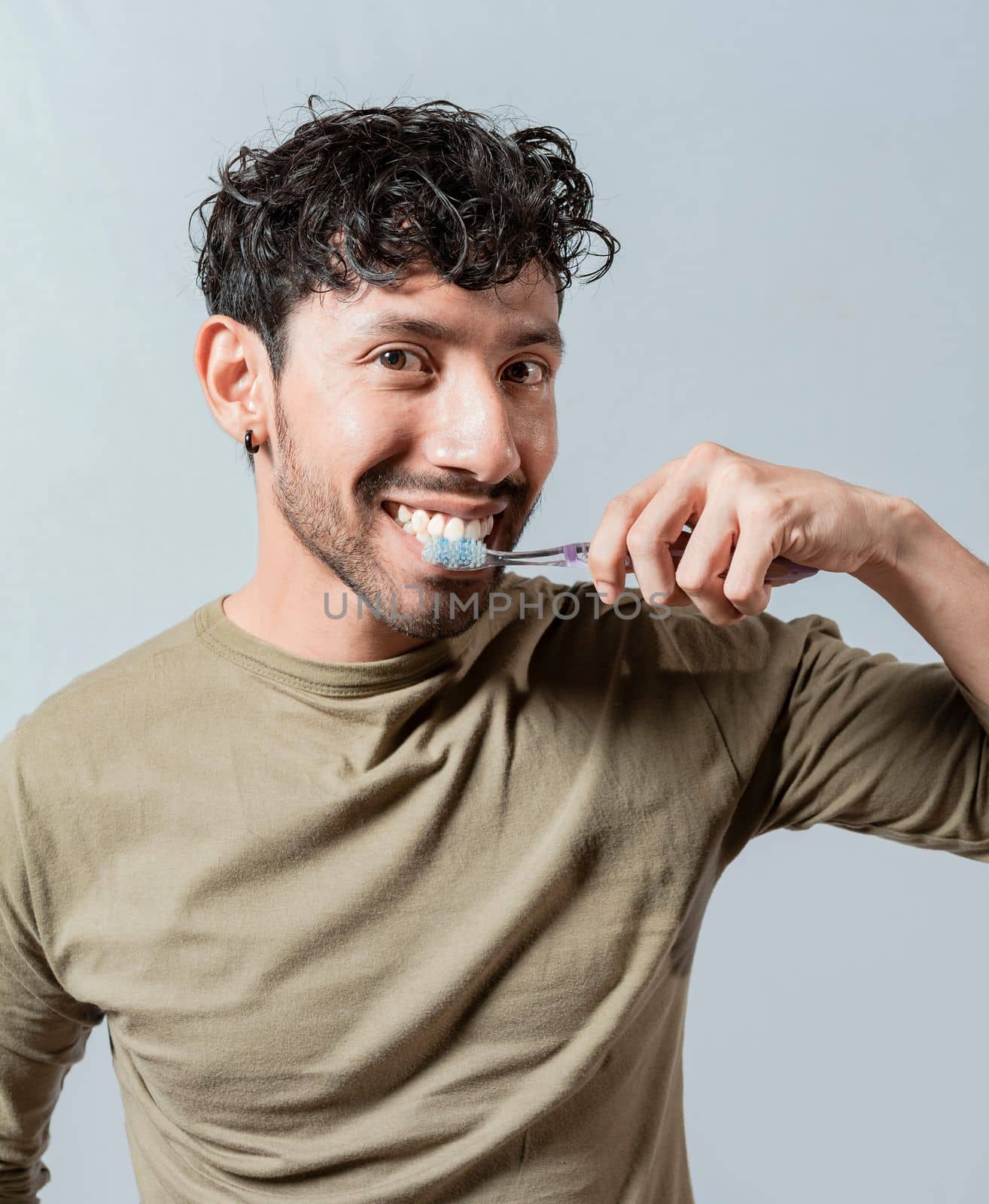 Smiling man brushing his teeth isolated, Face of handsome man brushing his teeth. Tooth brushing and care concept. Face of guy brushing teeth isolated. Oral and dental smile concept