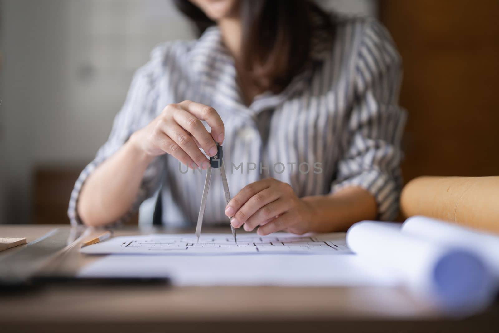 Architect woman working with blueprints for architectural plan, engineer sketching a construction project, green energy concept.