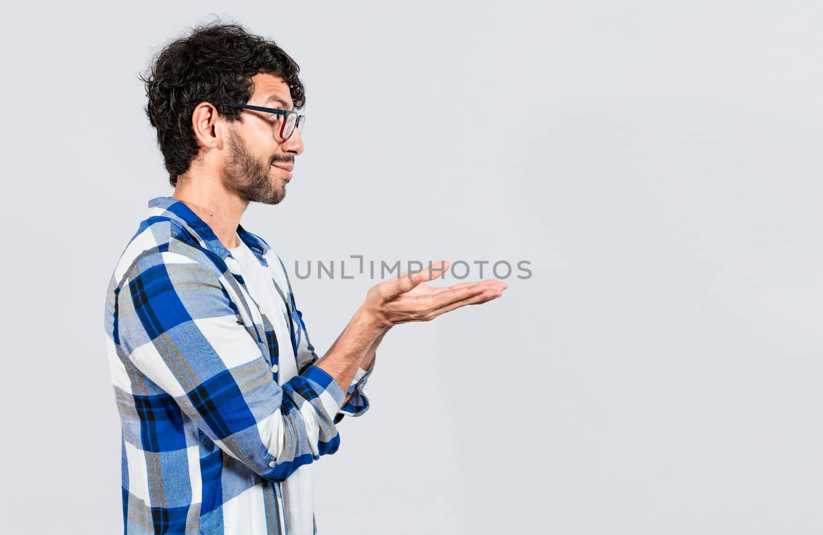 Smiling person recommending a product with his hands, Man recommending an advertisement with the palm of his hands. Guy recommending an ad space isolated