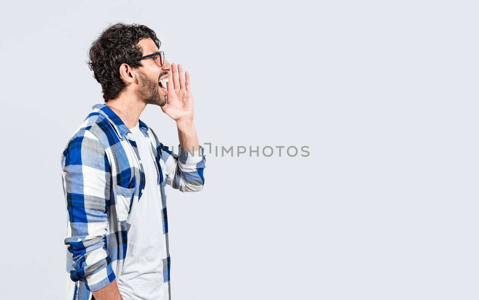Handsome bearded man yelling and announcing a promotion, Side profile handsome guy yelling an announcement, isolated. Person shouting and announcing a banner.