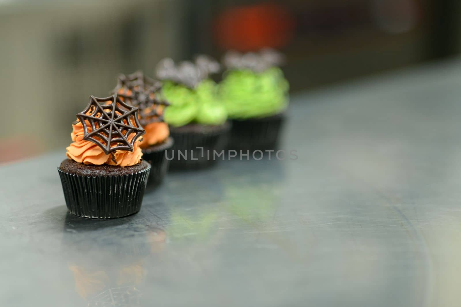 pastry chef baker preparing halloween green orange monster cupcakes handmade by verbano