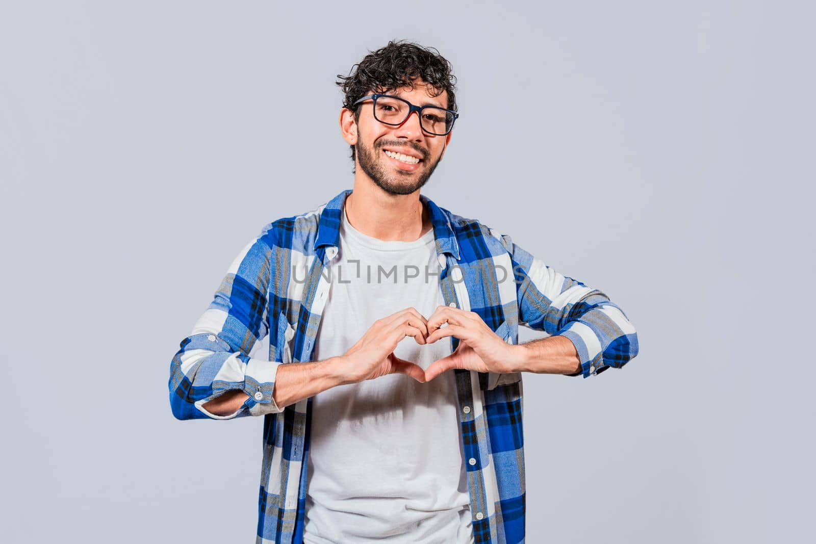 Teenage guy making heart shape with hands isolated. Happy man making heart shape with hands isolated. Person putting hands together in a heart shape
